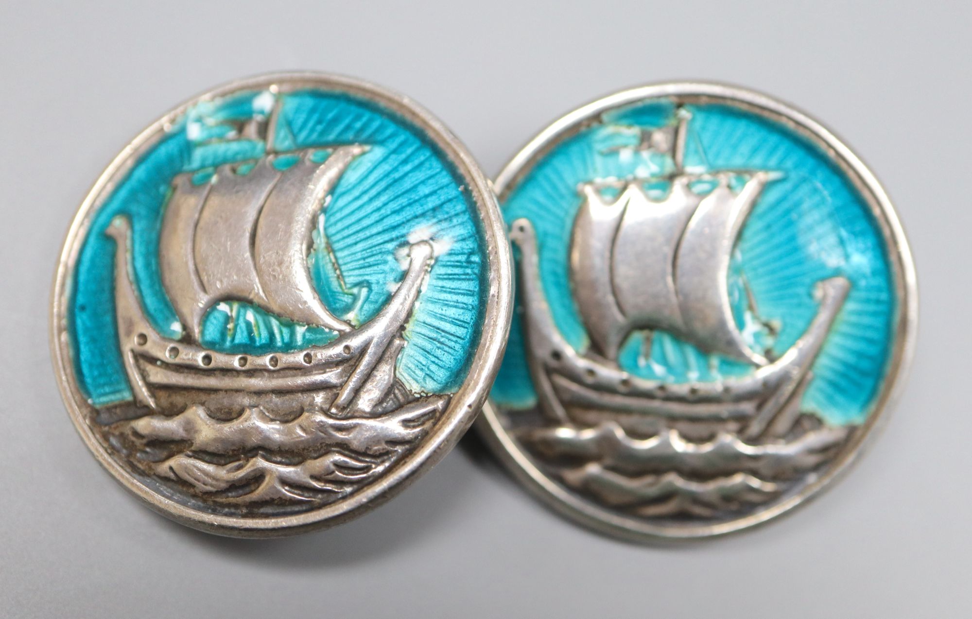 A pair of white metal (stamped silver) and enamel longboat circular cufflinks, 27mm, gross 25.7 grams.